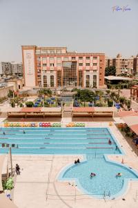 a large swimming pool in a city with buildings at Rehana Plaza Hotel in Cairo