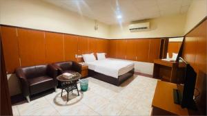 une chambre d'hôtel avec un lit, une chaise et une télévision dans l'établissement Lulu guest house, à Ras al Khaimah