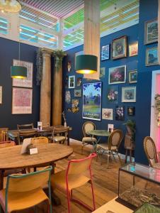 un restaurante con mesas y sillas y una pared azul en Victoria Villas en Sandycroft