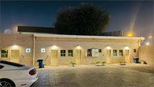 une voiture garée devant un bâtiment la nuit dans l'établissement Lulu guest house, à Ras al Khaimah