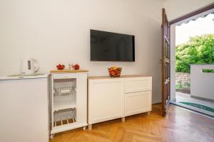 sala de estar con TV en la pared en Apartment & Double Room Stanka, en Baška