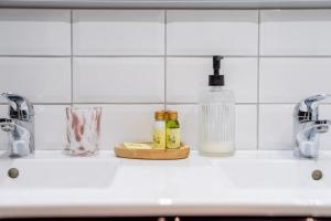 um lavatório de cozinha com duas torneiras e duas garrafas em Appart Hypercentre CLIM 2chb QuartierChic em Aix-en-Provence