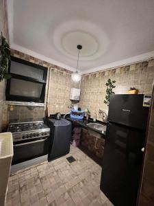 eine Küche mit einem schwarzen Kühlschrank und einer Spüle in der Unterkunft Corniche Glimpse in Alexandria