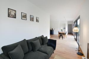 a living room with a couch and a table at Le Guillaume - Sauna - A moins de 2 km de la plage in Sainte-Honorine-des-Pertes