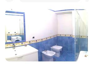 a bathroom with a toilet and a sink and a mirror at VILLA AZZURRA in Gaeta
