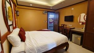 1 dormitorio con cama, lavabo y TV en Mo rooms en Chiang Mai