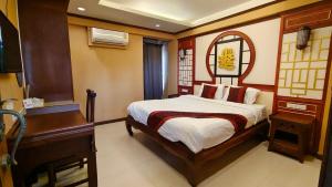 1 dormitorio con cama, escritorio y piano en Mo rooms en Chiang Mai