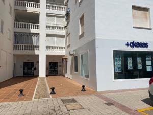 um parque de estacionamento vazio em frente a um edifício em Coqueto apartamento a un tiro de piedra de la playa del Portil em El Portil