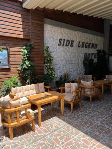 patio z kanapami i stołami oraz znakiem na budynku w obiekcie Side Legend Hotel w Side