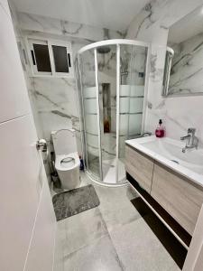 La salle de bains est pourvue d'une douche, de toilettes et d'un lavabo. dans l'établissement Piso Lorena 170m playa Wifi aire, à Puerto de Sagunto
