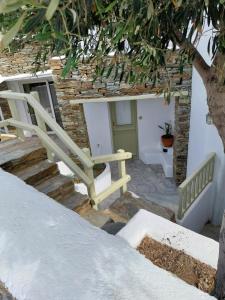 un conjunto de escaleras con un banco y un árbol en Altana Boutique Hotel, en Tinos