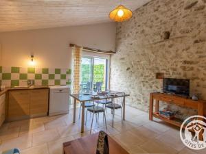 a kitchen and dining room with a table and chairs at Gîte cosy entre Cholet et Puy du Fou, terrasse, accueil PMR, proche sites touristiques, parking inclus - FR-1-622-32 in Saint-Christophe-du-Bois