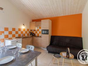 a kitchen and a living room with a table and a couch at Gîte champêtre proche Puy du Fou avec terrasse, parking privé et tout inclus ! - FR-1-622-31 in Saint-Christophe-du-Bois +2 photos