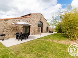 an external view of the cottage with a table and an umbrella at Gîte champêtre proche Puy du Fou avec terrasse, parking privé et tout inclus ! - FR-1-622-31 in Saint-Christophe-du-Bois