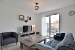a living room with a couch and a table at Ty Guen Braz - Charmante maison avec jardin in Plurien
