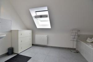 a bathroom with a sink and a skylight at Ty Guen Braz - Charmante maison avec jardin in Plurien +13 photos