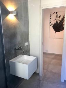 bagno con lavandino bianco in camera di Lalli's Flat ad Aci Castello