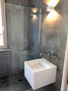 un bagno con un lavandino bianco e una doccia di Lalli's Flat ad Aci Castello