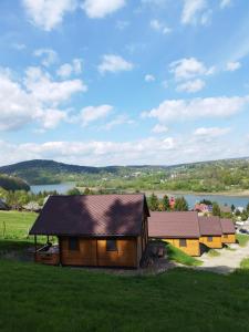 a group of cottages with a lake in the background at Pod Bercem in Solina