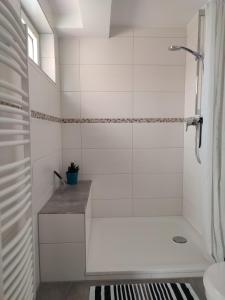 uma casa de banho branca com um chuveiro e um lavatório. em Ferienwohnung Trifts | Einzelbetten | Parkplatz em Wangen im Allgäu