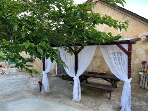 two trees with white curtains in front of a building at Casita rural con piscina in La Torre de Claramunt