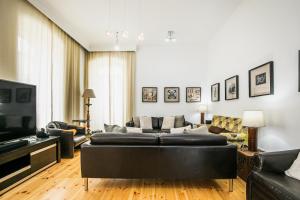 uma sala de estar com um sofá e uma televisão em Casa de Santo António 