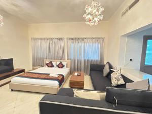 a bedroom with a bed and a couch at Al Hayat Suites Apartment in Manama