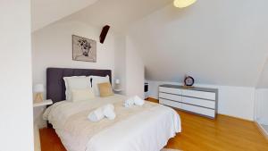 a bedroom with a large white bed with white pillows at Triplex Le Bel Âtre in Sélestat
