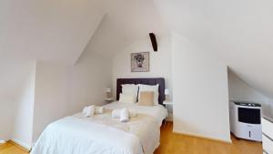 a bedroom with a large bed with white sheets at Triplex Le Bel Âtre in Sélestat