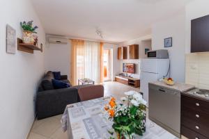 a kitchen and living room with a couch and a table at Apartments Stašić Katarina in Soline