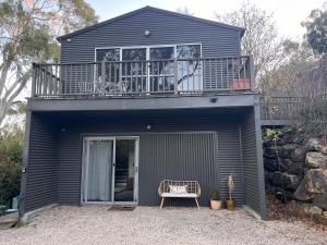 Casa pequeña con balcón y silla en Peaceful Hills Escape: Charming 2-Story Retreat, en Upper Sturt