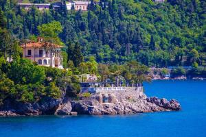 a house on a rocky island in the water at Villa Volos,free private parking in Opatija
