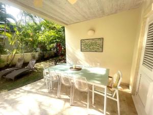 a dining table and chairs on a patio at Shimmers, stunning, stylish West Coast Villa in Saint Peter