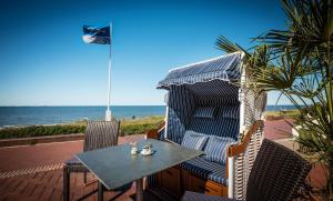 万根沃格Strandhotel Gerken的带桌椅的露台和大海