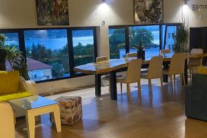 a dining room with a table and chairs and windows at British Hotel Pogradec in Pogradec