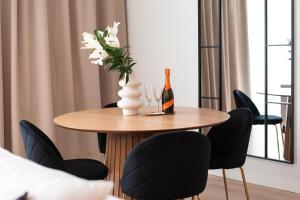 einen Tisch mit einer Flasche Wein und eine Vase mit Blumen in der Unterkunft Flatbook - City Center Apartments Granaria I in Danzig