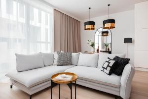 ein Wohnzimmer mit einem weißen Sofa und einem Tisch in der Unterkunft Flatbook - City Center Apartments Granaria I in Danzig