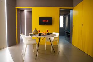 uma sala de jantar com paredes amarelas e uma mesa e cadeiras em Fiveplace Design Suites & Apartments em Trapani