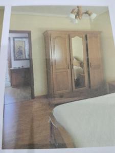 a bedroom with a bed and a wooden cabinet at apartamento torrealtina in Luarca +5 photos