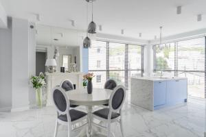 a white kitchen with a table and chairs at Mi Bella 1 in Gdynia