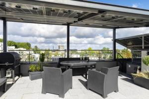 a patio with a table and chairs on a roof at Mi Bella 1 in Gdynia