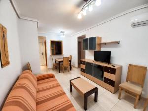 ein Wohnzimmer mit Couch und Fernseher in der Unterkunft Costa Azahar II Nº 1041 in Oropesa del Mar
