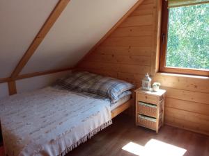 a bedroom with a bed and a window at Domek Stokrotka in Krynica Zdrój