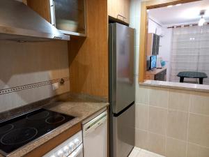 eine kleine Küche mit einem Kühlschrank und einem Herd in der Unterkunft Costa Azahar II Nº 1041 in Oropesa del Mar