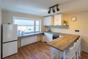 a kitchen with a refrigerator and a wooden table at Kalda apartment in Kärdla