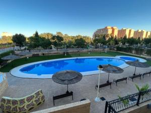 ein großer Pool mit Sonnenschirmen und Stühlen in der Unterkunft Costa Azahar II Nº 1041 in Oropesa del Mar