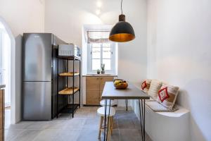 a kitchen with a table and a refrigerator at Casa Ladeira in Loulé