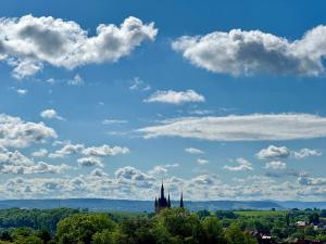 een kasteel in de verte met een blauwe lucht en wolken bij Gästehaus Fernblick in Bad Wimpfen