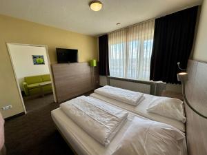 een hotelkamer met 2 bedden en een televisie bij Gästehaus Fernblick in Bad Wimpfen