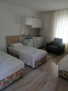 a hotel room with two beds and a chair at Kiriş Banana Suit in Kemer